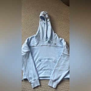 Champion hoodie sweatshirt .  Light blue crop style with small front zipper .